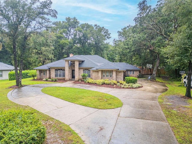 view of front of property featuring a front yard, curved driveway, a chimney, and fence