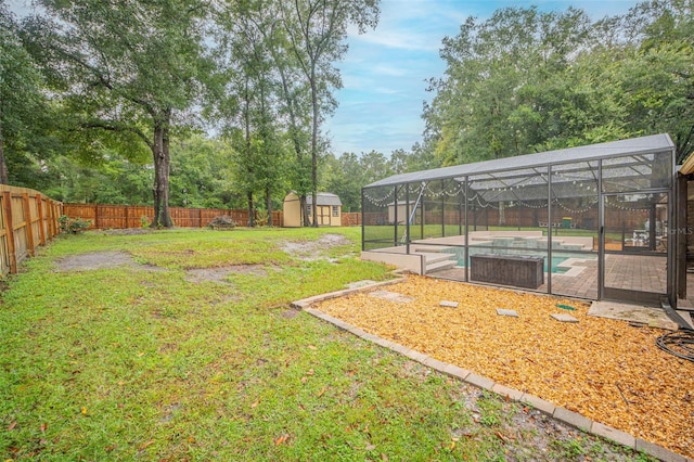 view of yard featuring a fenced backyard, a lanai, an outdoor structure, a fenced in pool, and a storage unit