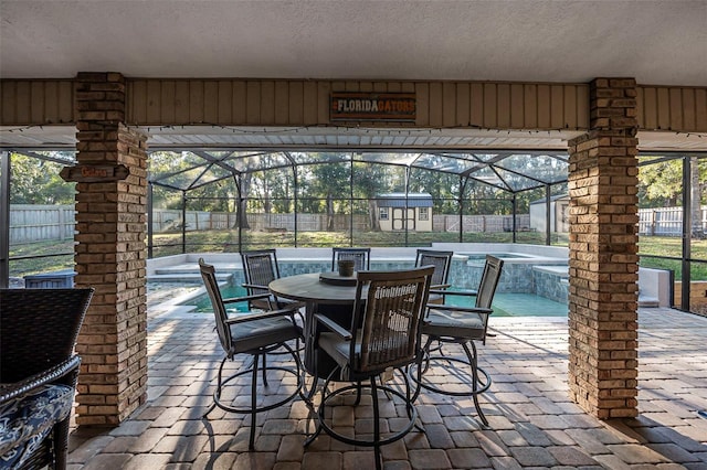 view of patio / terrace with a fenced backyard, a lanai, an outdoor structure, a fenced in pool, and a storage unit