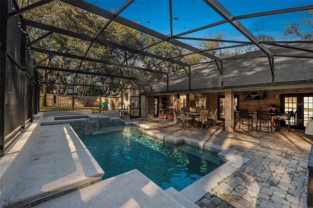 view of swimming pool featuring glass enclosure, a patio area, fence, and a pool with connected hot tub