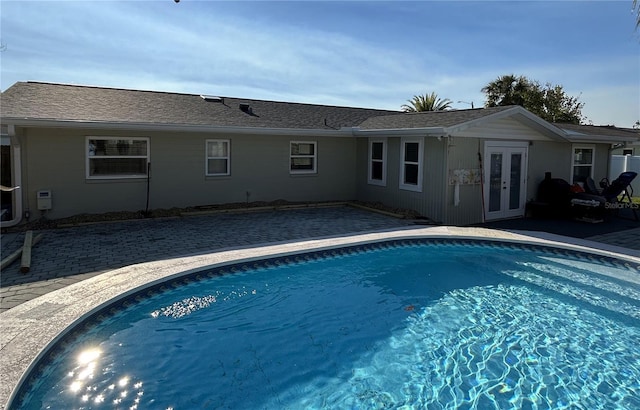 pool with french doors and a patio