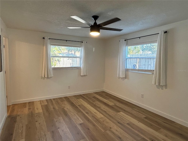 empty room featuring plenty of natural light, baseboards, and wood finished floors