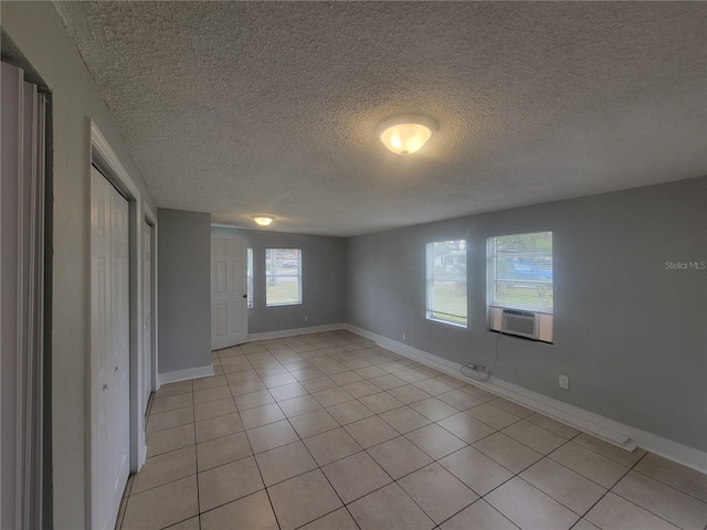 305 Elsie Ave, Daytona Beach, FL 32117 - unfurnished room with cooling unit, a textured ceiling, baseboards, and light tile patterned floors
