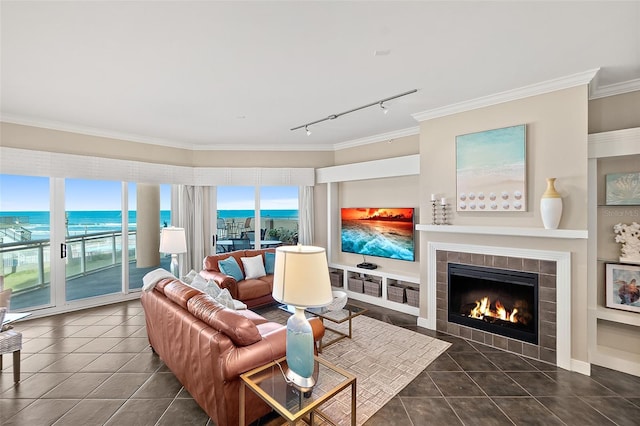 tiled living area with ornamental molding and a tile fireplace