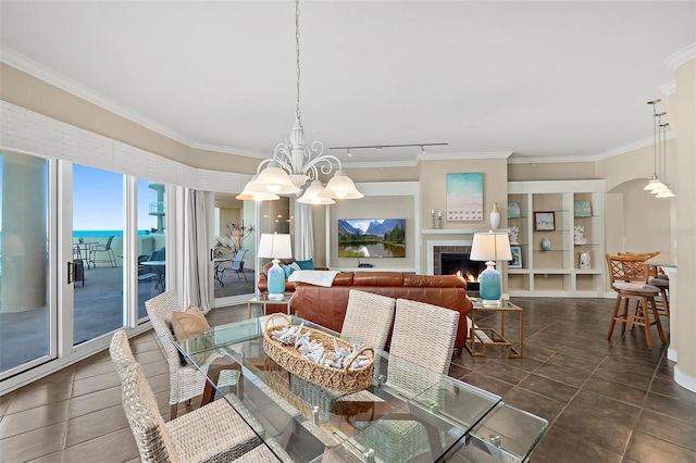 dining area featuring arched walkways, crown molding, a lit fireplace, tile patterned floors, and an inviting chandelier