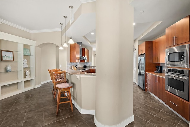 kitchen with a breakfast bar, dark tile patterned floors, arched walkways, and stainless steel appliances