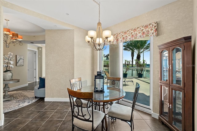 dining room with an inviting chandelier, a textured wall, baseboards, and dark tile patterned flooring