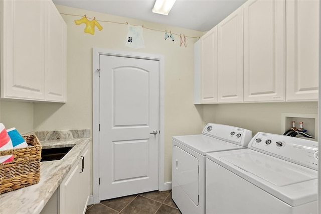 clothes washing area with cabinet space, dark tile patterned floors, and separate washer and dryer