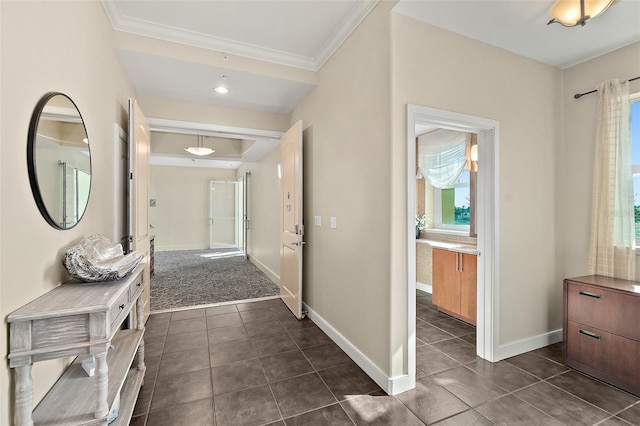 hallway with baseboards, crown molding, and dark tile patterned flooring