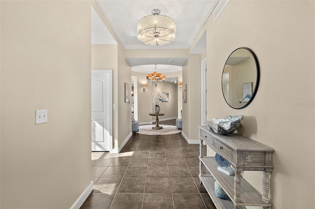 corridor featuring an inviting chandelier, baseboards, ornamental molding, and dark tile patterned flooring