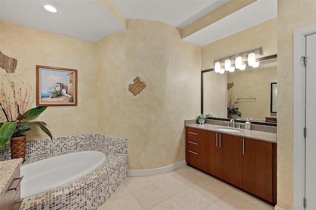 bathroom featuring a textured wall, tile patterned flooring, vanity, baseboards, and a bath