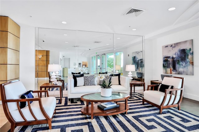 living area featuring recessed lighting, visible vents, and baseboards