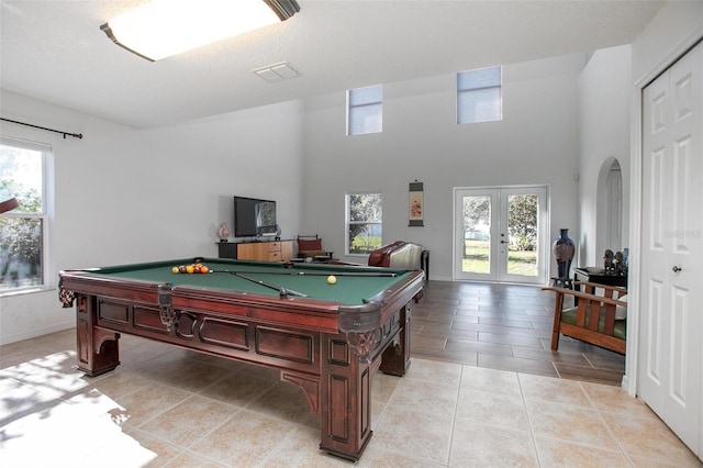 game room with pool table, arched walkways, a wealth of natural light, and french doors