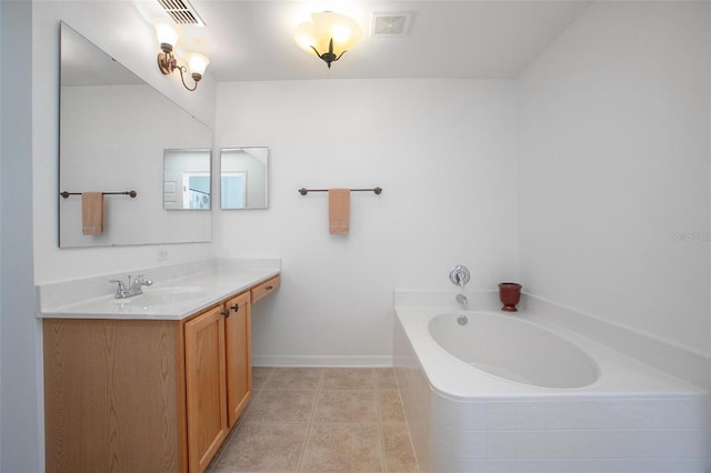 bathroom with a garden tub, vanity, baseboards, visible vents, and tile patterned floors