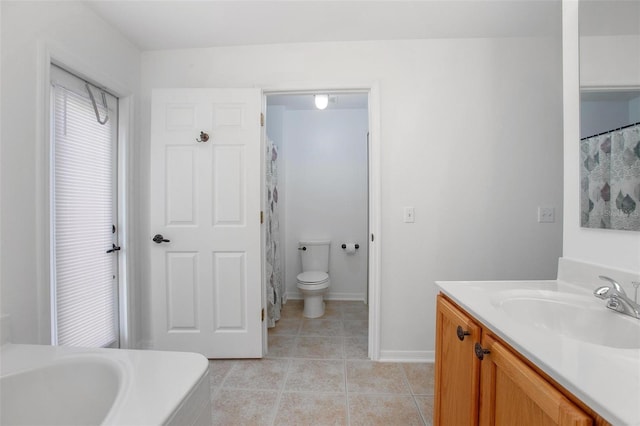 bathroom featuring toilet, tile patterned flooring, baseboards, and vanity