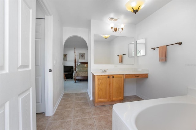 ensuite bathroom featuring visible vents, a tub, ensuite bathroom, tile patterned flooring, and vanity