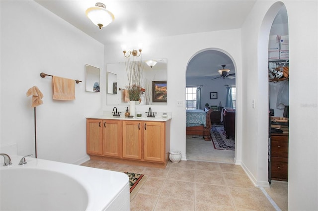 ensuite bathroom with a bathtub, a sink, ensuite bath, and tile patterned floors