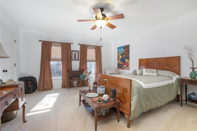 carpeted bedroom with ceiling fan and a textured ceiling