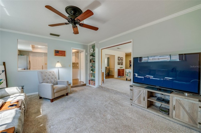 living room featuring carpet floors, visible vents, ornamental molding, and built in features