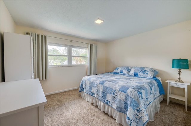 bedroom featuring baseboards and light colored carpet