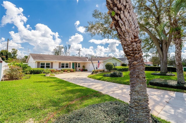 ranch-style home with driveway, stucco siding, a garage, and a front yard