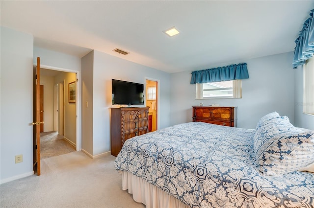 bedroom featuring baseboards, visible vents, and light colored carpet