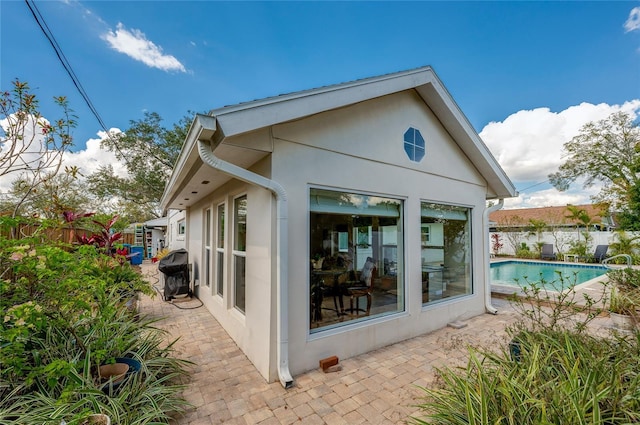 view of property exterior featuring a fenced backyard, a fenced in pool, a patio, and stucco siding