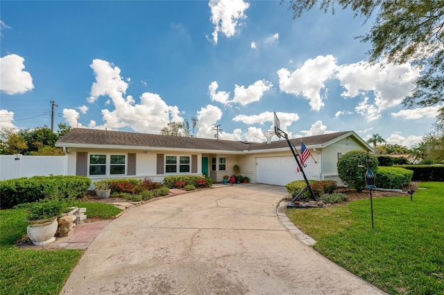 single story home featuring an attached garage, fence, concrete driveway, and a front yard