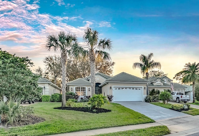 ranch-style home featuring a garage, concrete driveway, a tile roof, a front lawn, and stucco siding