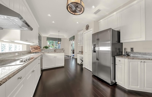 kitchen with stainless steel appliances, range hood, white cabinets, and visible vents