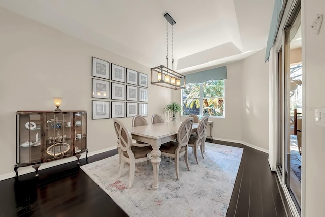 dining area featuring dark wood-style flooring and baseboards