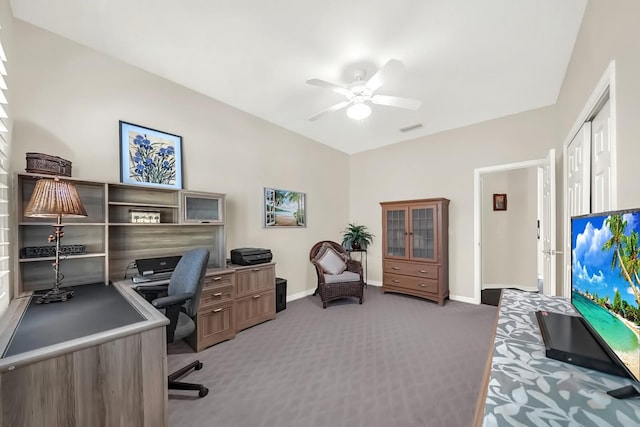 carpeted home office featuring visible vents, vaulted ceiling, a ceiling fan, and baseboards