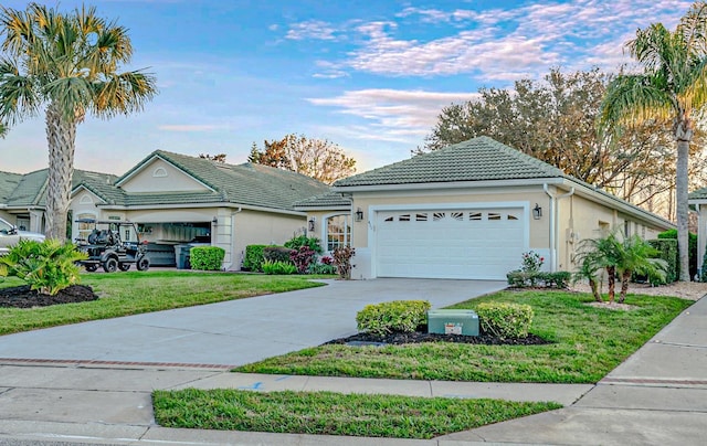 ranch-style house with a garage, concrete driveway, a tile roof, a front yard, and stucco siding