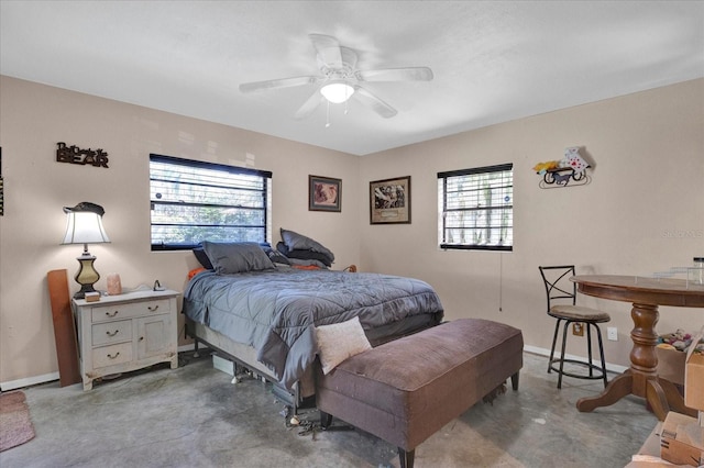 bedroom with a ceiling fan, baseboards, and concrete flooring