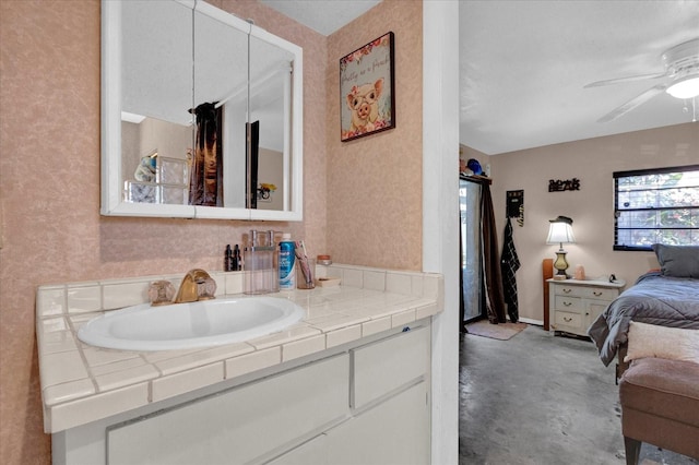 ensuite bathroom featuring concrete flooring, vanity, ensuite bathroom, and a ceiling fan