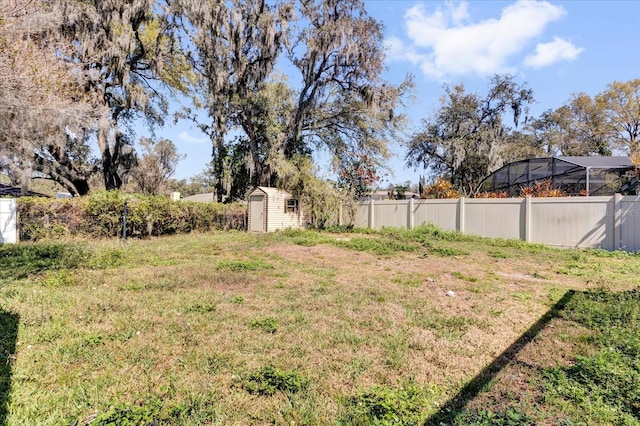 view of yard with an outbuilding, fence, and a storage unit