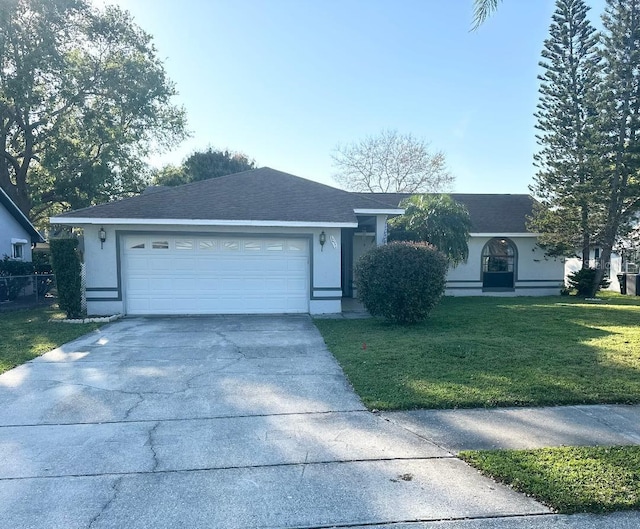 ranch-style house featuring concrete driveway, roof with shingles, an attached garage, a front lawn, and stucco siding