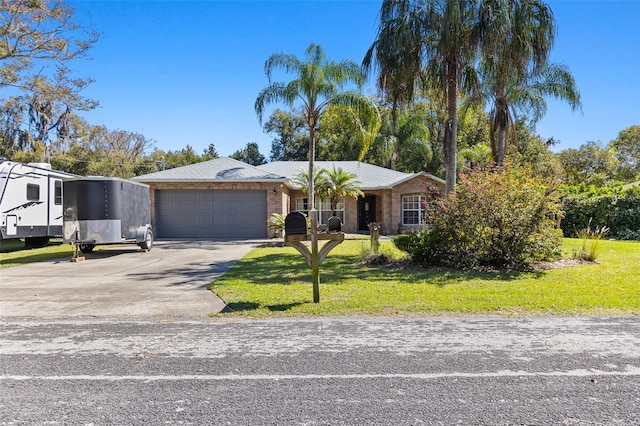 view of front of property with a garage, driveway, a front lawn, and brick siding