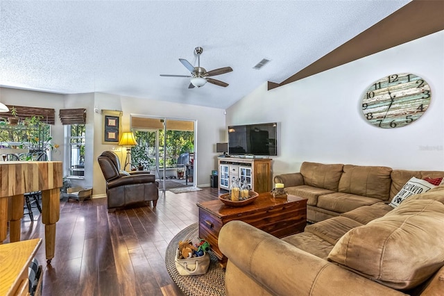 living room featuring visible vents, dark wood finished floors, a ceiling fan, vaulted ceiling, and a textured ceiling