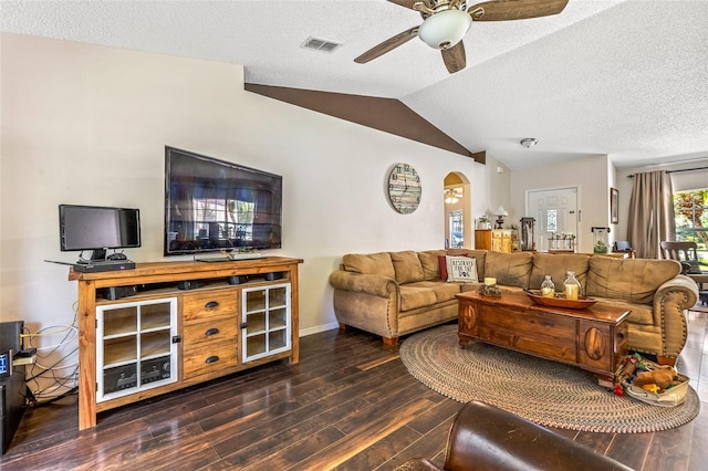 living room featuring visible vents, a ceiling fan, dark wood-type flooring, vaulted ceiling, and a textured ceiling