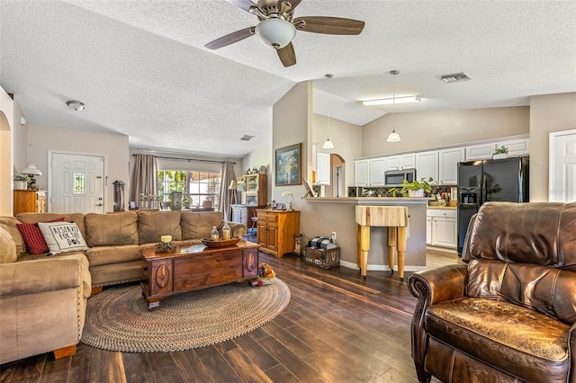 living area with visible vents, dark wood finished floors, a ceiling fan, lofted ceiling, and a textured ceiling