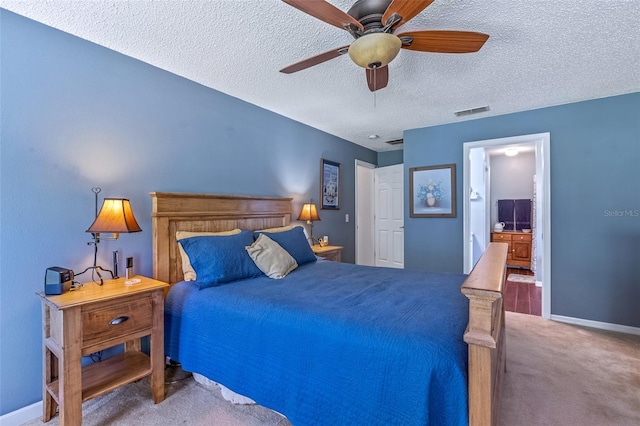 bedroom with a textured ceiling, carpet floors, visible vents, and baseboards