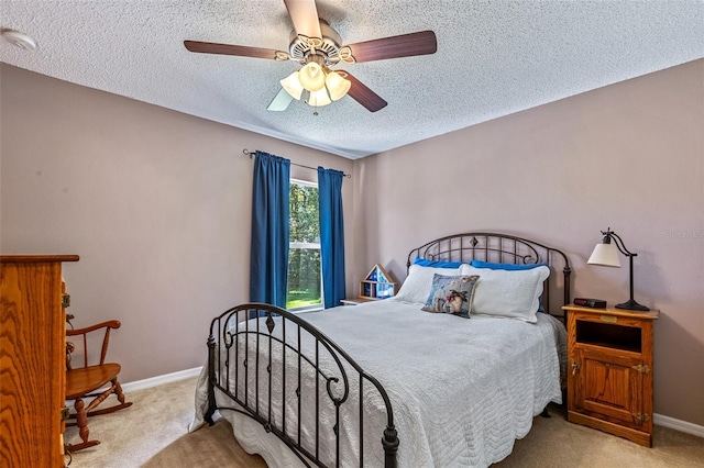 carpeted bedroom featuring ceiling fan, baseboards, and a textured ceiling