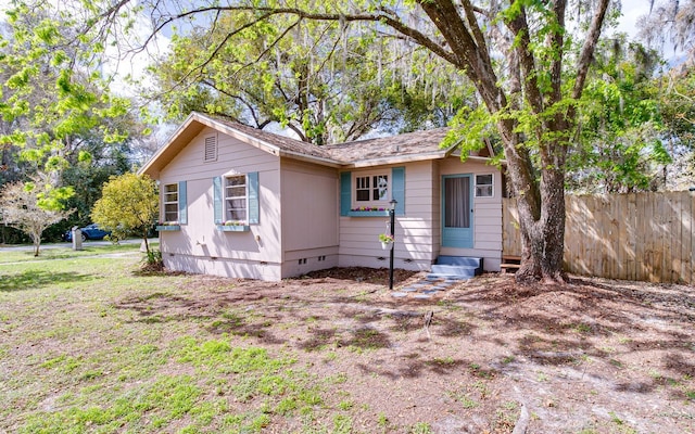 view of front of home with entry steps, crawl space, and fence