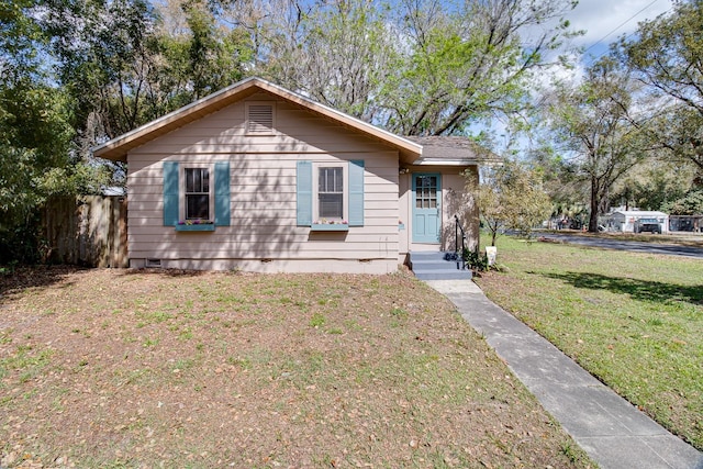 view of front of property with crawl space, fence, and a front yard