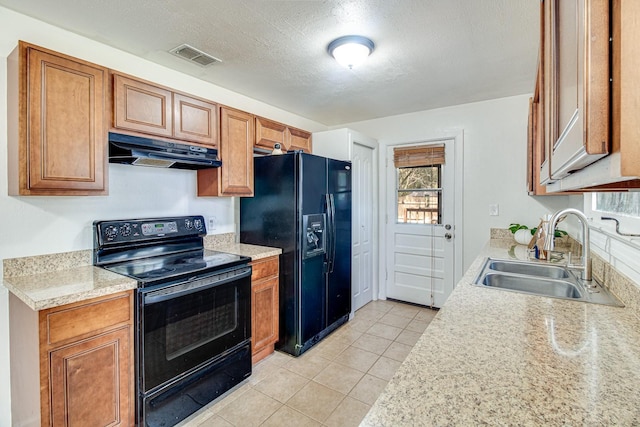 kitchen featuring visible vents, under cabinet range hood, light countertops, black appliances, and a sink