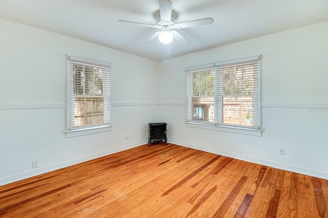 spare room featuring plenty of natural light, light wood-style flooring, and baseboards