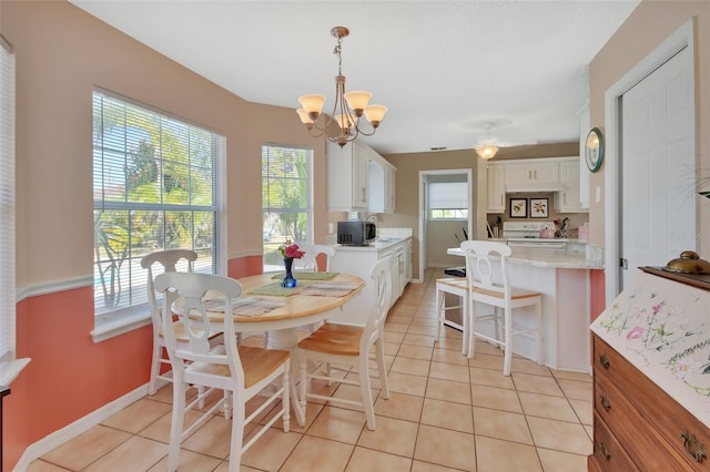 dining room with light tile patterned floors, a chandelier, and baseboards