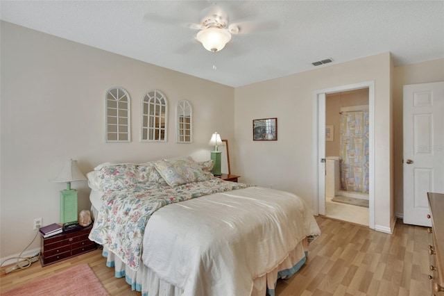 bedroom featuring light wood finished floors, a ceiling fan, visible vents, and a textured ceiling