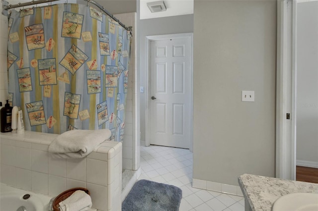 bathroom with a tub, vanity, baseboards, and tile patterned floors